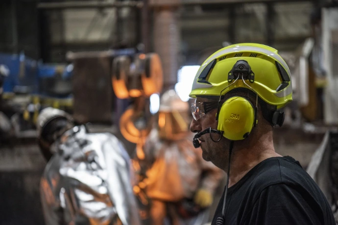 Technicien en milieu industriel portant un casque de sécurité avec protection auditive 3M-Peltor et micro radio
